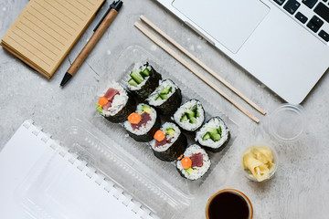 Food delivery concept. Lunch box with sushi set food delivery. Top view of assorted sushi, uramaki,...
