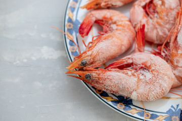 frozen shrimps on plate on ceramic background
