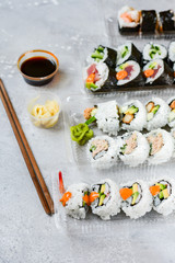 Food delivery concept. Lunch box with sushi set food delivery. Top view of assorted sushi, uramaki,...
