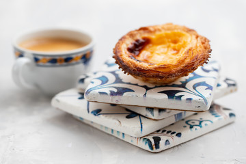 typical portuguese egg tart pastel de nata with cup of coffee on ceramic background