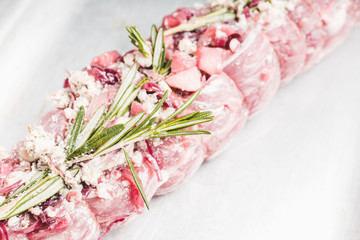 Raw pork loin with fruits, blue cheese and rosemary ready for baking. Selective focus. Shallow depth of field.