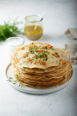 Traditional Russian pancakes with salmon and herbs