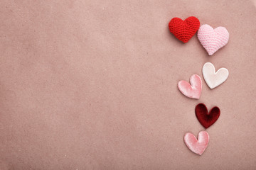 Valentine's day decorative background. Fabric hearts on craft paper. Flat lay, top view, copy space