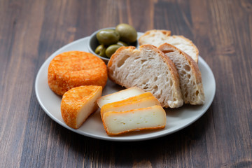 appetizer cheese with bread and olives on dish