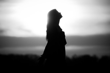 Youth woman soul at white sun meditation awaiting future times. Silhouette in front of sunset or...