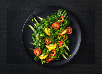 fresh chopped vegetables salad on a black plate view from above