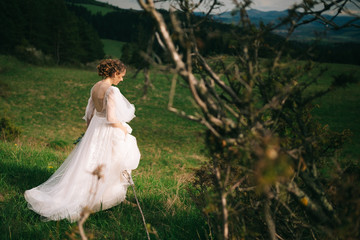 beautiful bride in white dress posing in nature