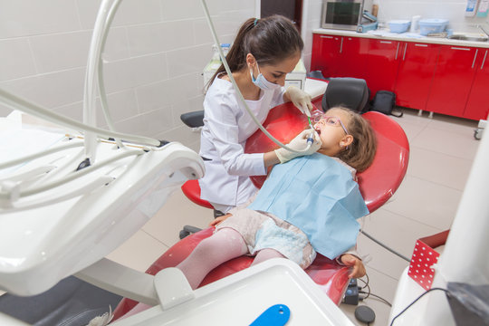 A Child With A Dentist In A Dental Office.