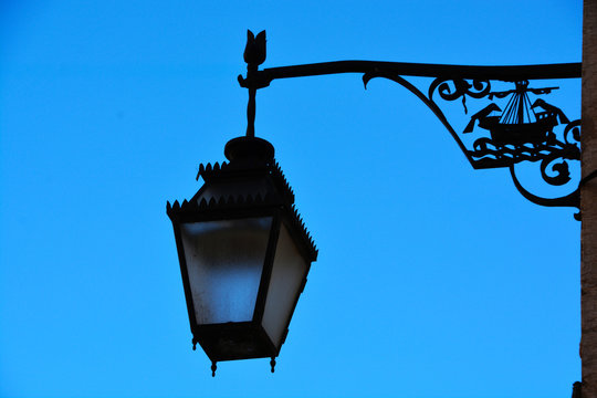 Lamp on the bracket with decoration in the form of a ship on the wall of the house