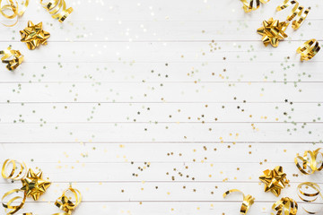 Gold confetti stars and ribbons on a White background. Copy space Flat lay. Greeting card for...
