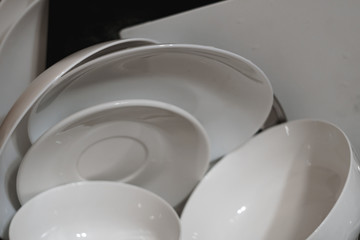 Bunch of just washed dishes piled upon a drier