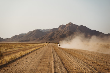 Fototapeta premium 4x4 through heat haze travelling on an unsealed desert sand road