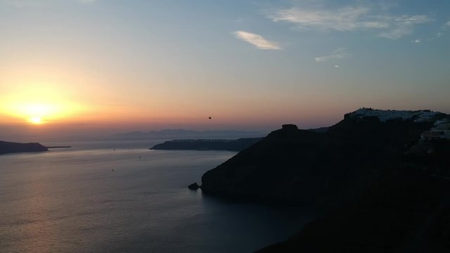 Aerial view on the Fira capital of Santorini at summer evening. Low light raw footage