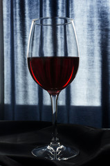 Closeup of glass of red wine. Dark atmosphere at the restaurant