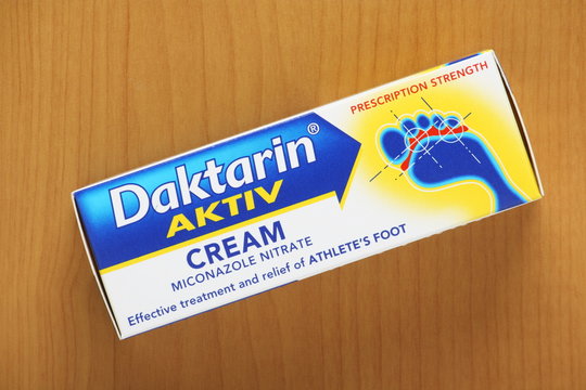 Box container of Daktarin Aktiv cream for the treatment of athlete's foot on a table top on September 02, 2014 in England