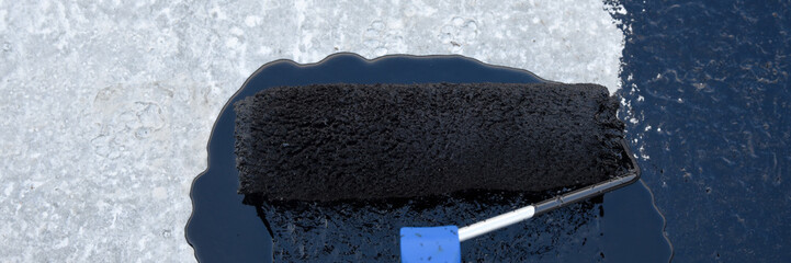 Worker applies bitumen mastic on the foundation