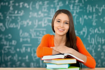 Young female college student and stack book on table at library background