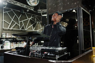 Obraz na płótnie Canvas African american dj play music on decks at night club.