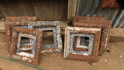 Up cycled rusted square picture frames on the ground
