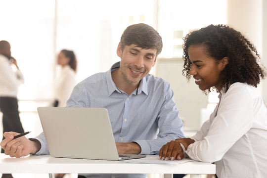 Diverse Man And Woman Work Using Laptop In Office Together