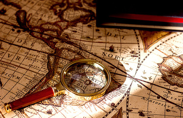 Fototapeta na wymiar old vintage world map magnifying glass and book, travel and tourism concept