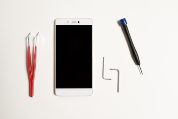 Repair of a cellular phone in the service with a special tool. Cellular phone repair tool on a white background.