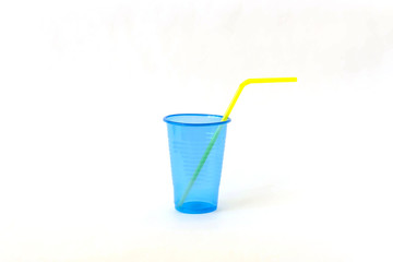 Blue empty disposable plastic glass with yellow drinking straw isolated on a white background.