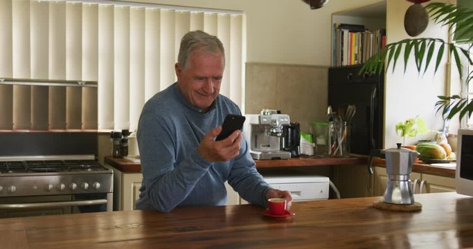 Senior man using mobile phone at home