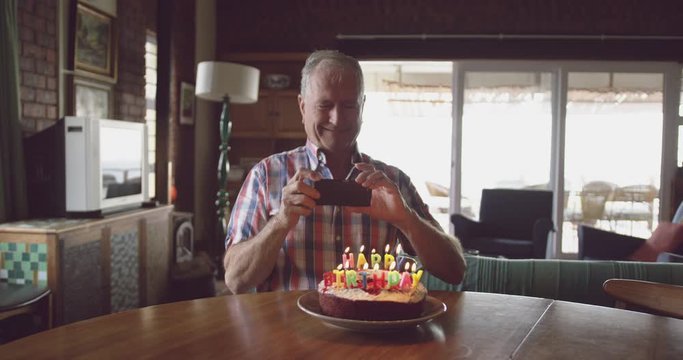 Senior man with a birthday cake at home