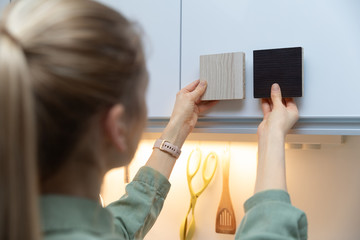 woman choosing kitchen cabinet materials from laminate samples