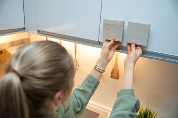 woman choosing kitchen cabinet materials from laminate samples
