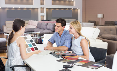 Man and woman are consulting about colors of sofa.