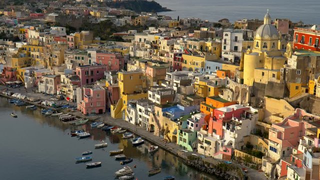 Marvelous sunset view of Island of Procida. Naples, Italy. Colourful italian houses in Corriccella village in Procida island. Panning shot, UHD