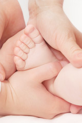 Woman and the young girl hold the baby