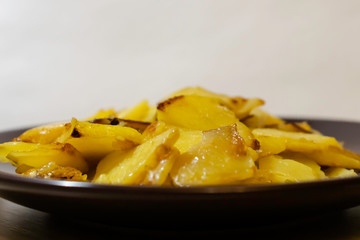 Fried homemade potatoes in a plate. For presentations, menus, illustration recipes. Side view