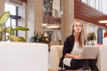 Young successful purposeful attentive business woman for meeting in restaurant with investors or business partners. Discussion of project, advertising and promotion. Work on laptop anywhere remotely.