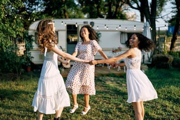 Happy beautiful women dancing outdoors on picnic
