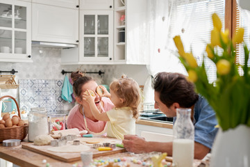 Playful family enjoy baking cookies together