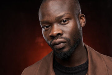 Obraz premium portrait of a black handsome guy on a red background who is looking at the camera