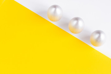 Easter holiday composition. Three eggs of silver color on a double yellow-white background. Easter flat ley. Easter concept. Copyspace.