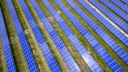 aerial view of solar panels on green lawn. drone shot, bird's eye