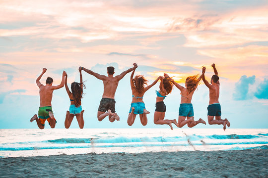 Happy successful friends jumping on the beach