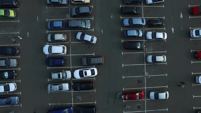 Drone footage cars parking at congested parking lots. people walking parking