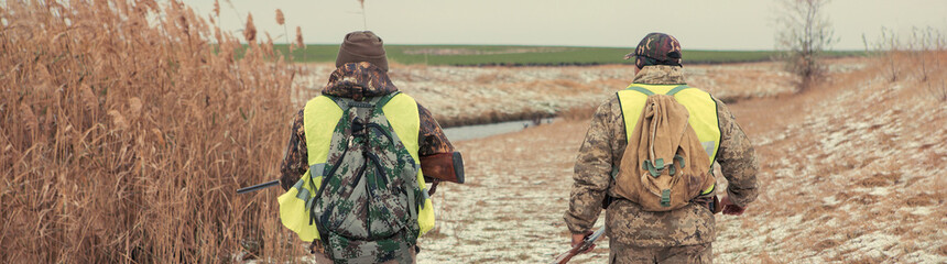 Hunting period, autumn season open. A hunter with a gun in his hands in hunting clothes in the...