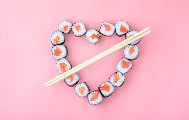 Papier Peint photo Bar à sushi Rouleaux de sushi au saumon disposés en forme de coeur sur fond rose. Le concept de cuisine japonaise pour la Saint-Valentin, carte de voeux, bannière. Espace de copie