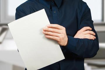 man holding blank sheet of paper. Young guy pointing at paper sheet. Promotion concept.