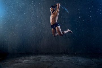Fototapeta na wymiar Wet shirtless gladiator jumping in attack.