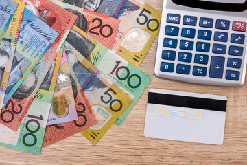 Cash and credit card. Colorful australian dollar banknotes with plastic banking card and calculator on table. Financial system