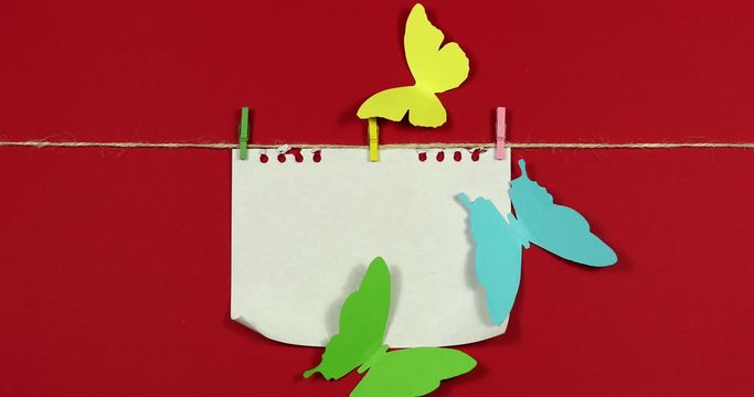 Animated stop motion. A butterfly flies out of an unfolding white sheet of paper.