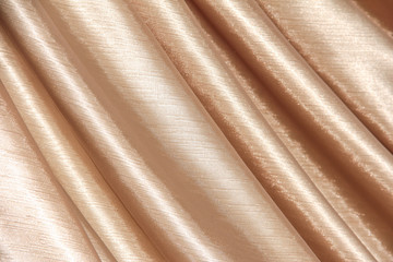 Beige background of curtains draped with waves